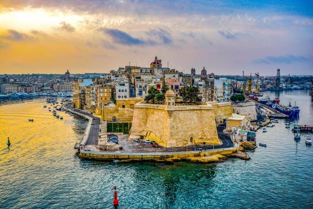 A kép Málta fővárosát, Vallettát és a Grand Harbour (Nagy Kikötő) nevű természetes kikötőt ábrázolja. A kikötő a föníciaiak kora óta jelentős szerepet tölt be, és azóta hatalmas erődítésekkel vették körül.  - Z(s)eppelin utazás