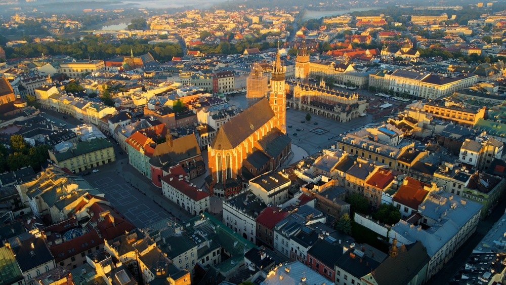 A krakkói Mária-templom (Bazylika Mariacka) és a Fő tér (Rynek Główny) látható a képen naplementekor. 